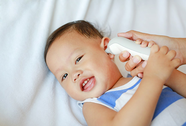 bébé et thermomètre auriculaire